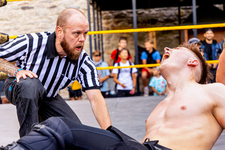Marko Simonen of Kayfabe Diary working as a professional wrestling referee in 2023, with Estonian pro wrestler Artur Arder.